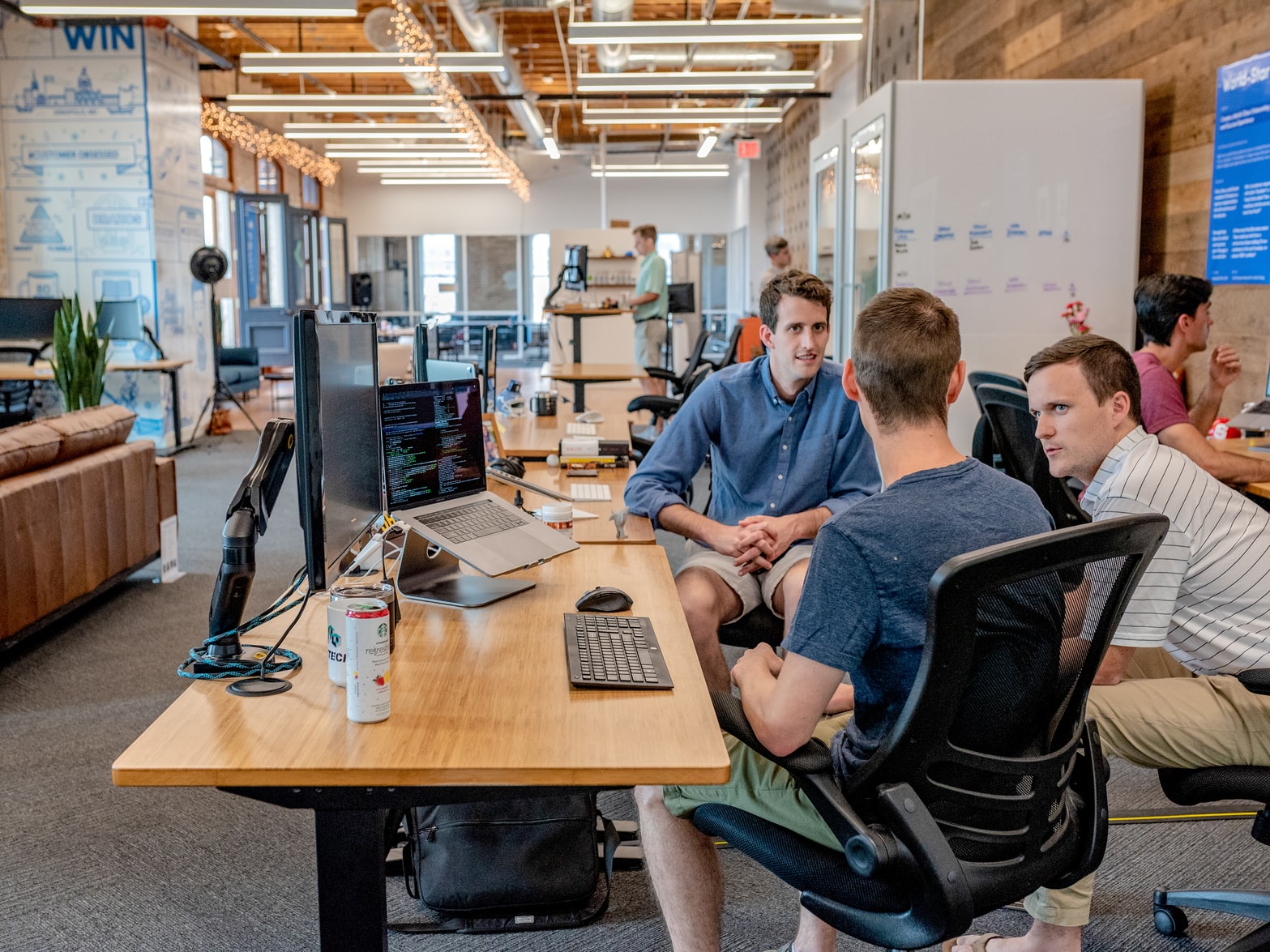 Colleagues looking at a monitor together at a shared desk.
